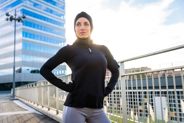Muslim sportive girl with fit body training outside - Beautiful woman with hijab doing some sport exercises, concepts about health, lifestyle and functional training - Фото, изображение