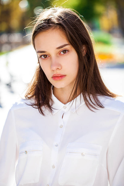 Close up portrait of a young beautiful girl in white shirt - 写真・画像