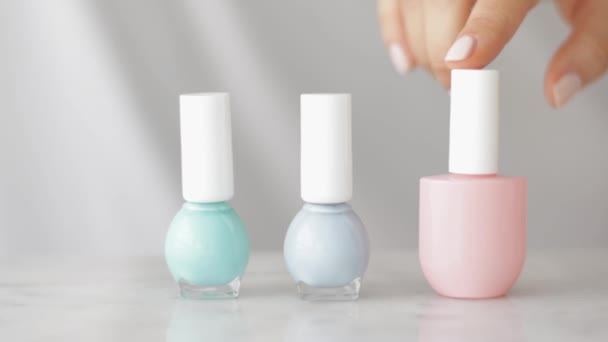 Natural beauty product scene, female hands and nailpolish bottles for french manicure, colourful pastel nail polish on marble table, make-up and cosmetic brand - Footage, Video