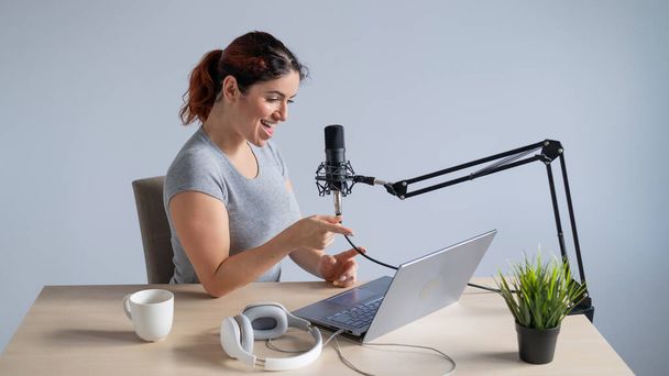 A charming woman radio host is broadcasting live on a laptop. Online radio concept - Fotó, kép