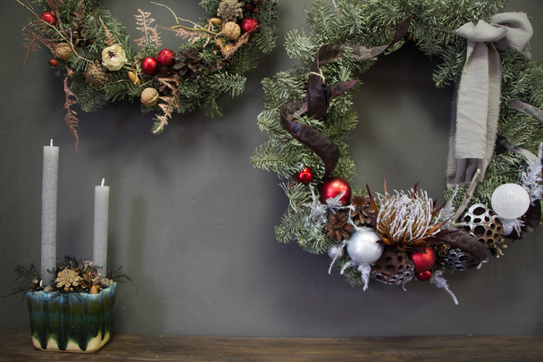 Grinaldas de Natal de videiras decoradas com ramos de abeto, bolas de Natal e materiais naturais e composição com velas, conceito de Ano Novo - Foto, Imagem