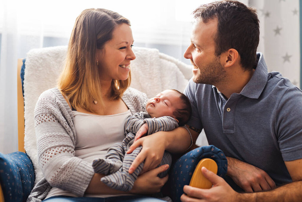 Parents and Baby having wonderful time sit on chair one the bedroom - Photo, Image