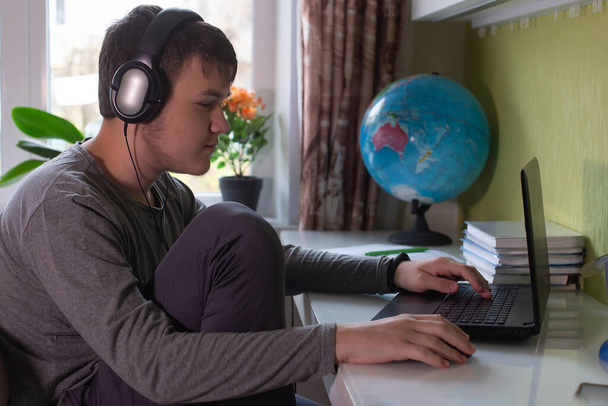 the Schoolboy sits at home at his laptop - Φωτογραφία, εικόνα