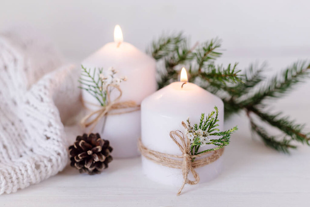 Рождественские свечи, сувенирные и еловые ветви на белом деревянном фоне с огнями. Открытки с копировальным местом - Фото, изображение