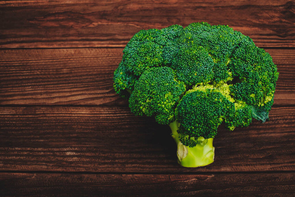 Fresh green broccoli on wooden background. Fresh broccoli on a wooden table. - Фото, зображення