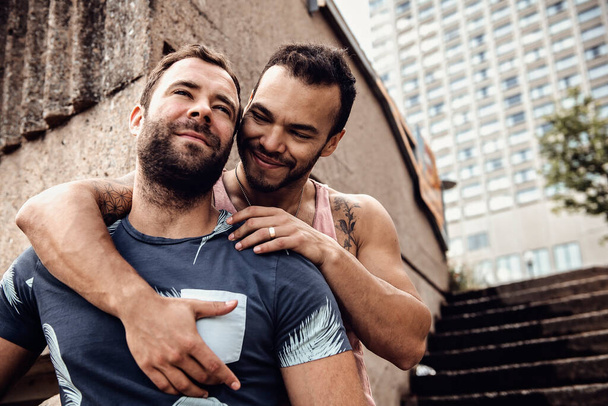 Портрет счастливой гей-пары на открытом воздухе в городском фоне - Фото, изображение