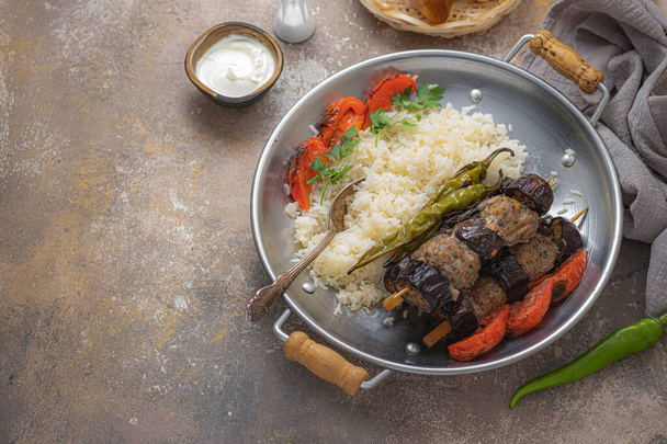 Turkish urfa kebab or eggplant kebabs on skewers with rice, copy space - Фото, изображение