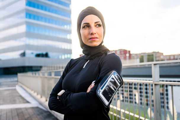 Muslim sportive girl with fit body training outside - Beautiful woman with hijab doing some sport exercises, concepts about health, lifestyle and functional training - Foto, Bild