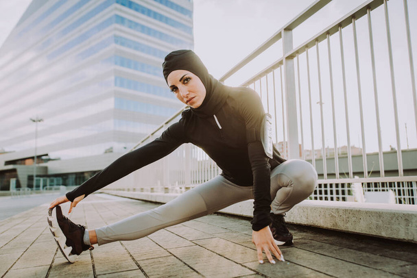 Muslim sportive girl with fit body training outside - Beautiful woman with hijab doing some sport exercises, concepts about health, lifestyle and functional training - Photo, Image