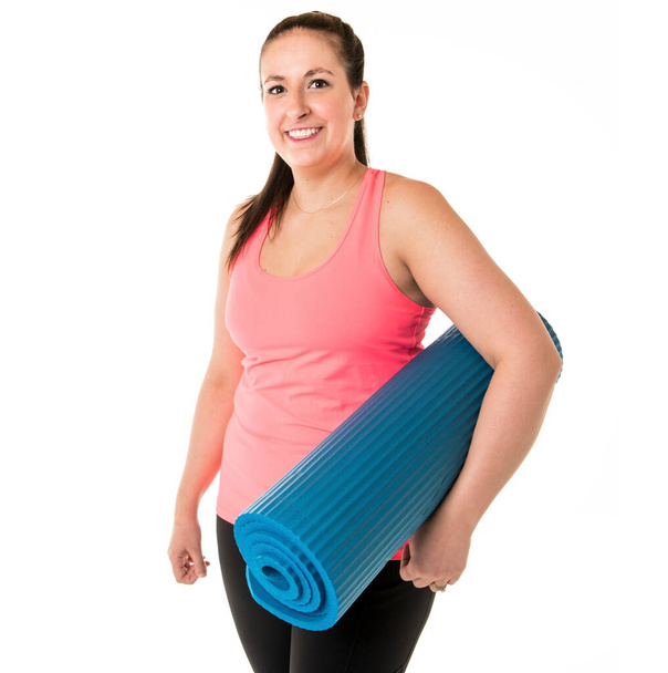 nice and Cheerful female fitness instructor holding mat - Foto, imagen