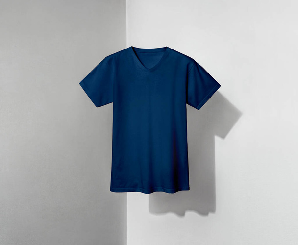 T-shirt bleu avec col en V et manches courtes sur fond gris et blanc - Photo, image