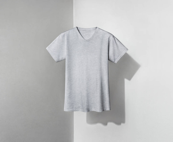 grey t-shirt with v-shaped neck and short sleeves on light background - Foto, Imagen