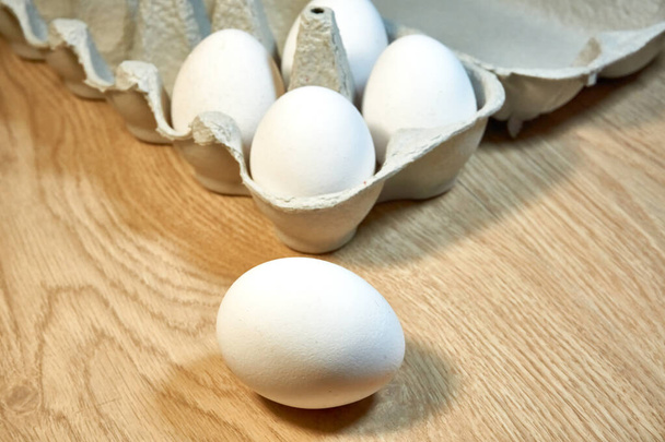 Masadaki karton kutuda çiğ tavuk yumurtası.. - Fotoğraf, Görsel