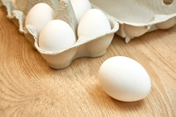 Uova di pollo crude in una scatola di cartone sul tavolo. - Foto, immagini