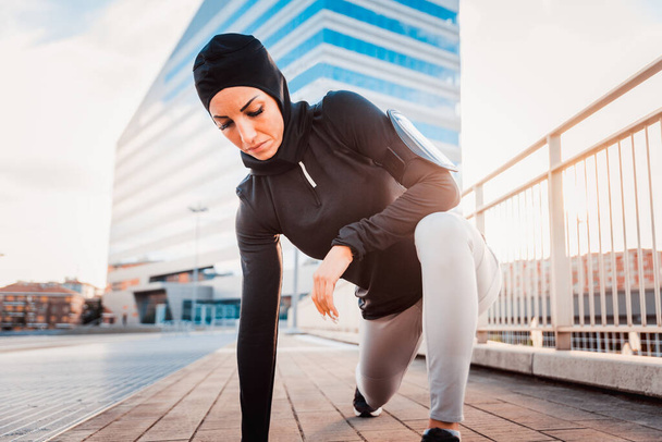 Мусульманская спортивная девушка с тренировкой тела снаружи - красивая женщина с хиджабом делает некоторые спортивные упражнения, концепции о здоровье, образе жизни и функциональных тренировок - Фото, изображение
