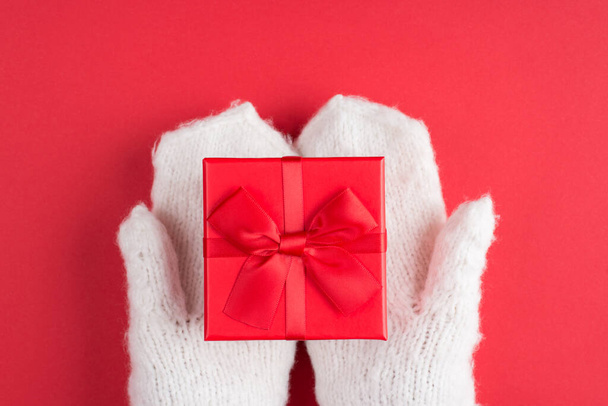 Top above overhead close up first person view photo of human female hands in mittens holding giving getting taking small square stylish closed present box isolated over vivid color background - Fotografie, Obrázek