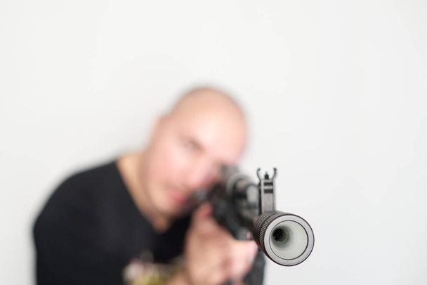 重いぼやけた男オンライト背景にライフルを手に - 写真・画像