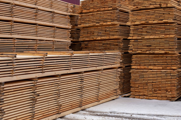 grandes pilhas de placas de madeira fundo com perspectiva linear. Armazenagem exterior de inverno. - Foto, Imagem