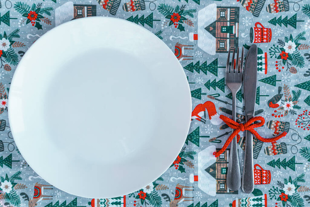 Xmas, winter, new year concept - layout white plate on which there are three Christmas trees cut from sausage cheese bread with santa hat and golden candles in form of numbers 2021 Blue background - Foto, Bild