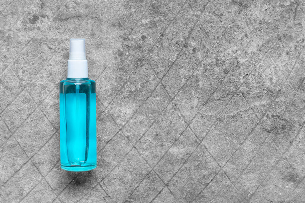Vista superior do frasco de spray higienizador de mão no piso de concreto. - Foto, Imagem