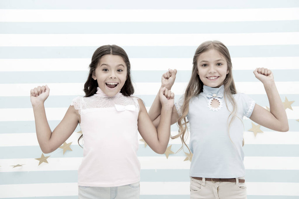Thrilled moments together. Kids schoolgirls preteens happy together. Girls smiling happy faces excited expression stand striped background. Girls children best friends thrilled about surprising news - Фото, зображення