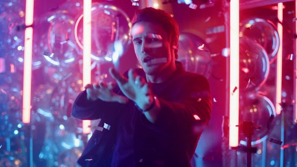 Szexi fickó, aki neon hátterű testmozgást végez. Férfi táncol a nightclubban - Fotó, kép