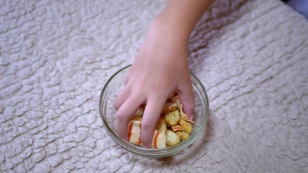 Το παιδικό χέρι παίρνει πατατάκια από ένα πιάτο στην κουζίνα. Υπάρχει Fast Food - Πλάνα, βίντεο