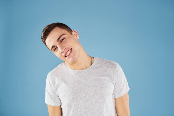 Uomo emotivo in bianco t-shirt vista ritagliata su sfondo blu stile di vita - Foto, immagini