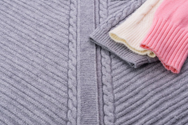 テクスチャ付きセーター編み物糸グレーピンクホワイト-抽象的な背景画像. - 写真・画像