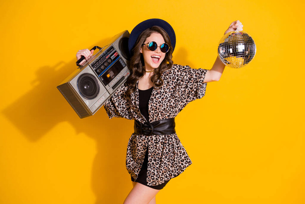 Photo of positive cheerful excited girl hold glitter ball boom box enjoy rejoice party wear skirt sunglass headwear isolated over bright shine color background - Fotoğraf, Görsel