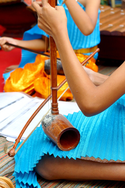 μια κοπέλα παίζει ένα τοπικό Ταϊλάνδης μουσικό όργανο. - Φωτογραφία, εικόνα