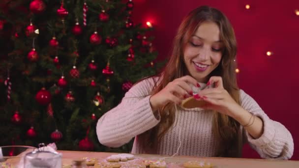 若いですかわいい女性作るクリスマスクッキーの装飾用の新年の家族の夕食 - 映像、動画