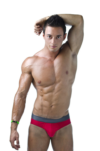 Cute muscular ripped young bodybuilder in bathing suit - Fotó, kép