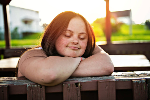 A Portrait of trisomie 21 adult girl outside at sunset - Fotoğraf, Görsel