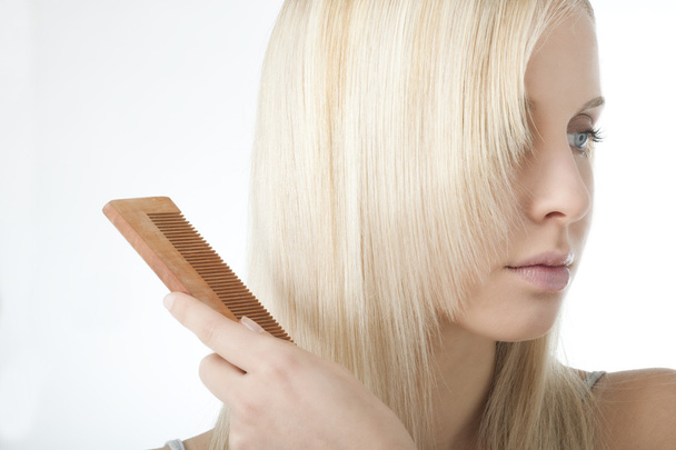 Blonde woman brushing her hair - Φωτογραφία, εικόνα