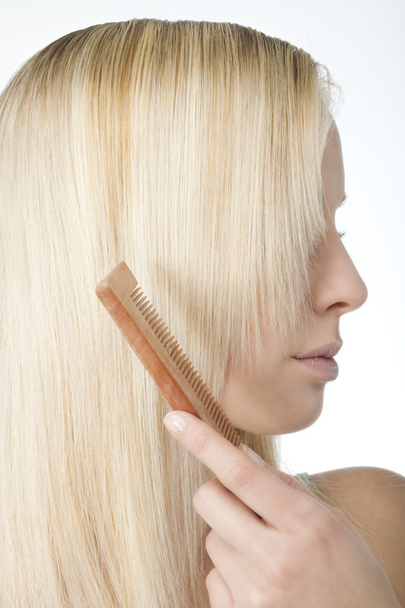 Blonde woman brushing her hair - Fotoğraf, Görsel
