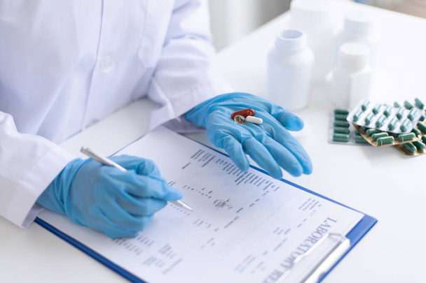 Lähikuva muotokuva, Tutkijat valkoisissa lab takit analysoivat elintärkeää ainetta näytteen huumeiden laboratoriossa, Lääketieteen tutkija hoitoon käsite.  - Valokuva, kuva