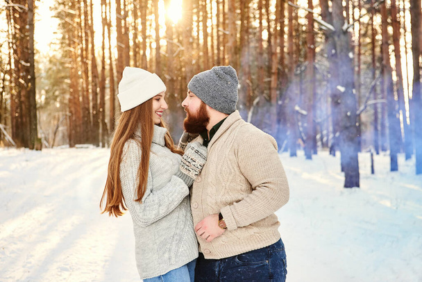 Бородатий хлопець і дівчина з довгим волоссям в зимовому одязі ходять, обіймаючись в засніженому парку. Ніжна, романтична, спокуслива, чуттєва пара збирається поцілувати. Справжня любов і почуття концепція зимових канікул. Різдво
 - Фото, зображення