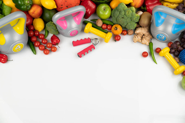 Kuntoilukonsepti. Terveellinen ravitsemus: hedelmät ja vihannekset. Kuntoilulaitteet: punnituslaite ja nuket. Valkoinen tausta
. - Valokuva, kuva