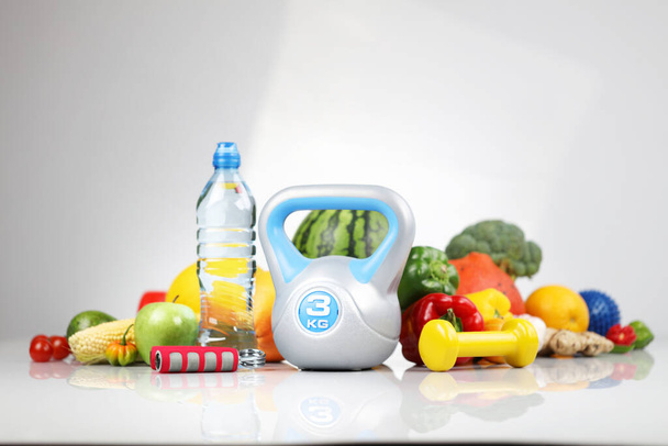 フィットネスコンセプト。健康的な栄養:果物や野菜。フィットネス演習のための機器:計量機とダンベル.白地. - 写真・画像