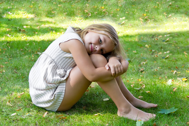 Cute girl sitting on green grass - Fotó, kép