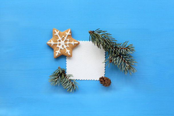 patterned empty blank decorated with a spruce branch and cookies on a blue background / place for congratulations - Foto, Imagem