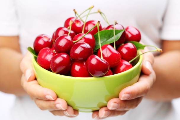 Crockery with cherries in woman hands. - Φωτογραφία, εικόνα