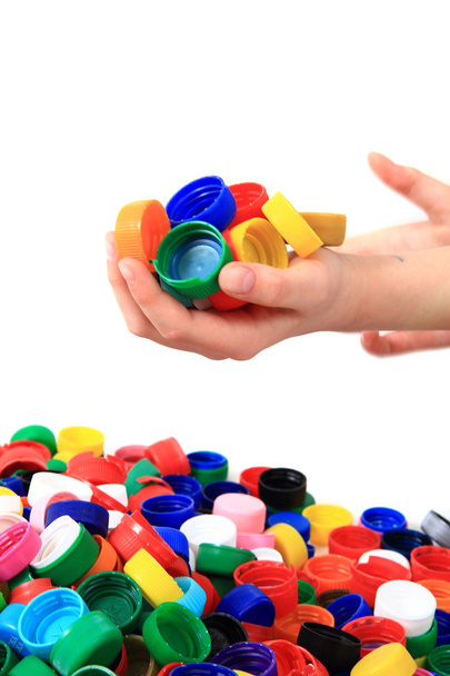 кольорові пластикові шапки в руках людини
 - Фото, зображення
