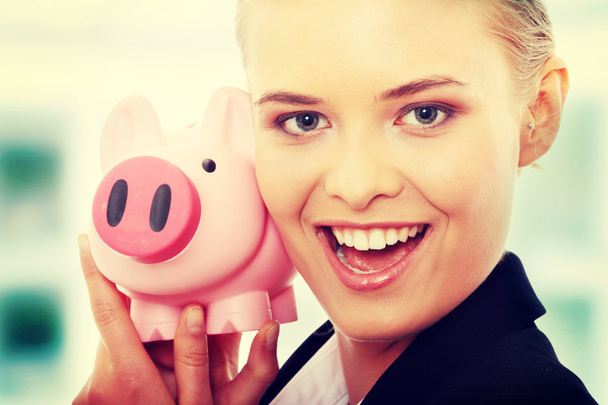 Businesswoman and piggy bank - Foto, afbeelding
