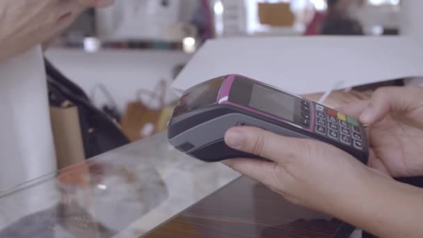 Cliente utilizzando smartphone per il pagamento in negozio - Filmati, video