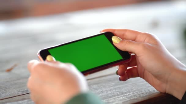 chica está sosteniendo un teléfono con una pantalla verde - Imágenes, Vídeo