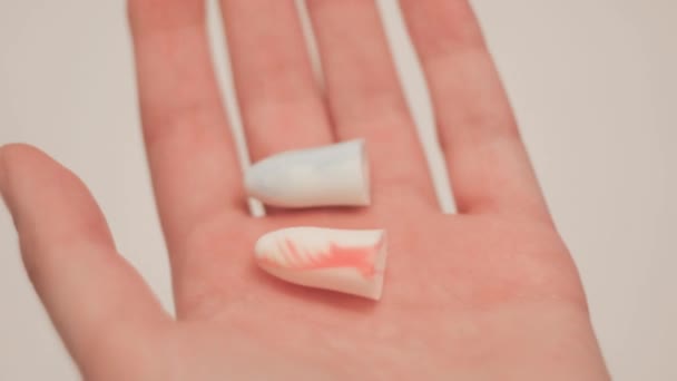 Close-up of ear plugs for ears in hand. Concept. Snoring keeps you awake, so woman suggests wearing earplugs. Earplugs for good nights sleep - Footage, Video
