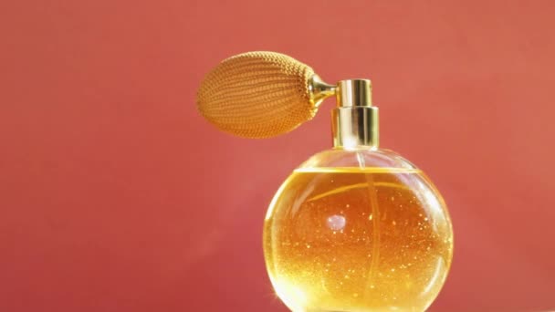 Золотая бутылка духов и яркие световые вспышки, шикарный аромат аромат в качестве роскошного продукта для косметической и косметической марки  - Кадры, видео