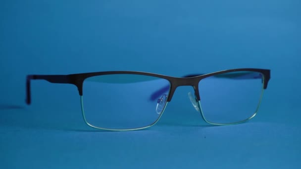 occhiali per l'occhio sono su uno sfondo blu - Filmati, video